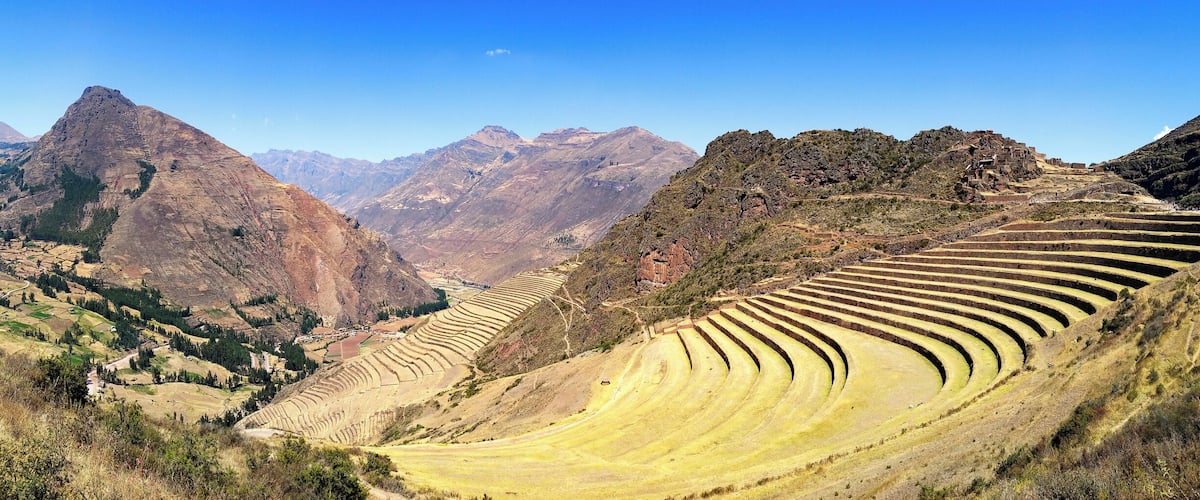 Terraced fields in a mountainous landscape with a clear sky.