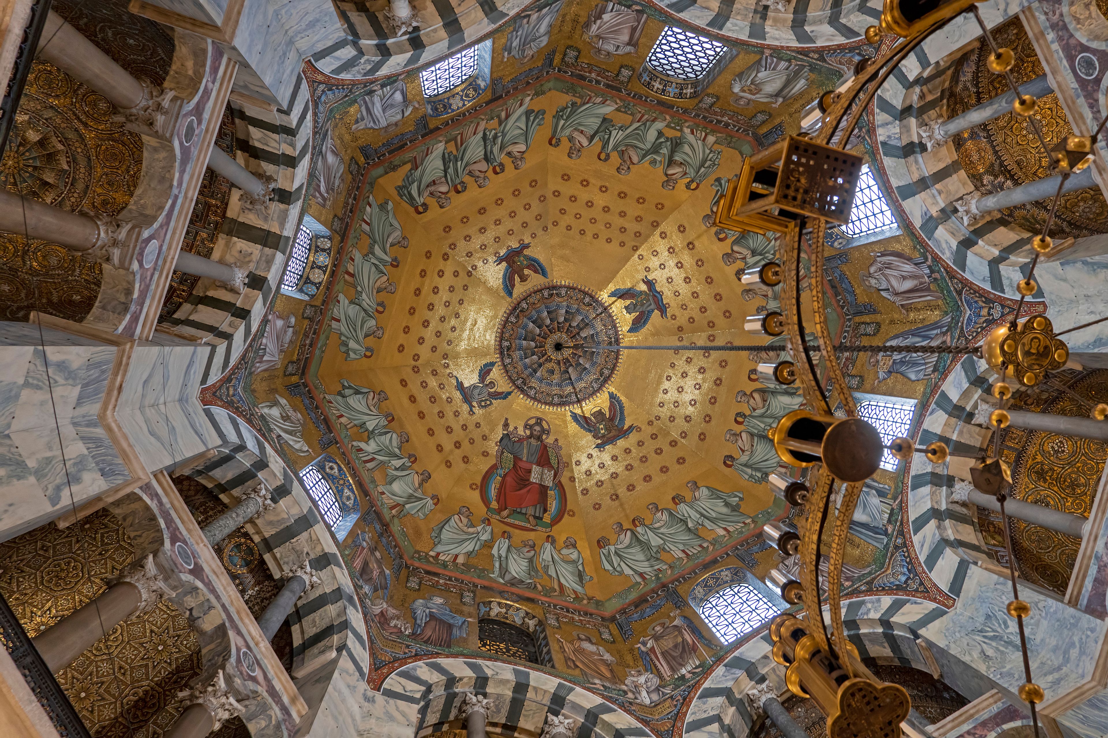 A domed ceiling with intricate mosaics and golden accents.