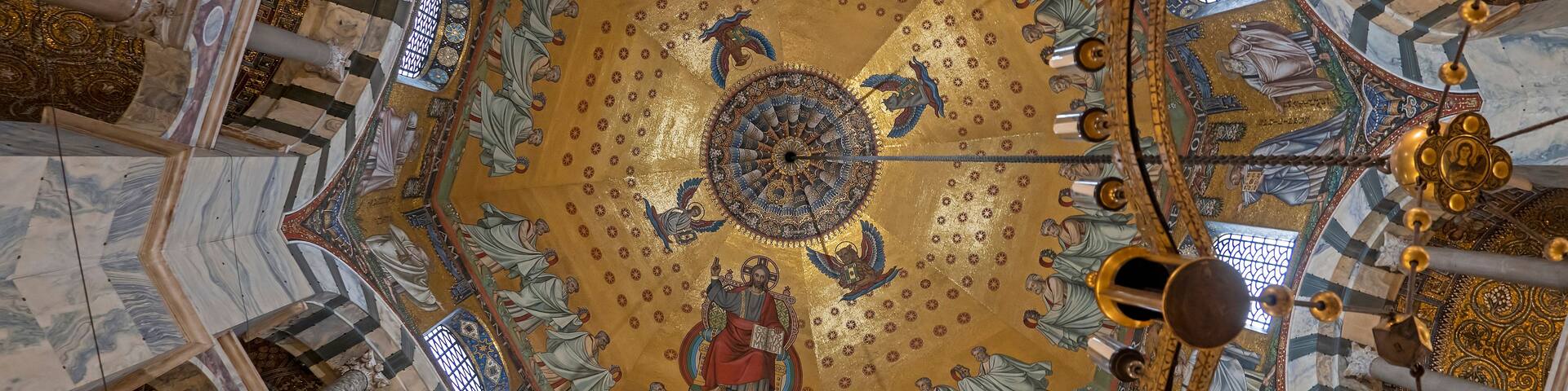 A domed ceiling with intricate mosaics and golden accents.