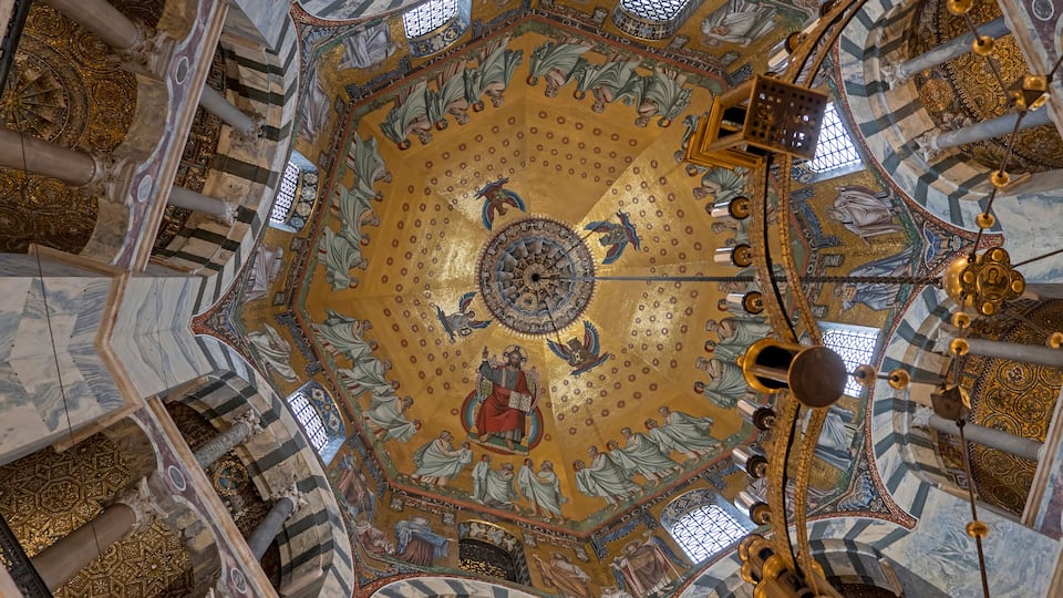 A domed ceiling with intricate mosaics and golden accents.
