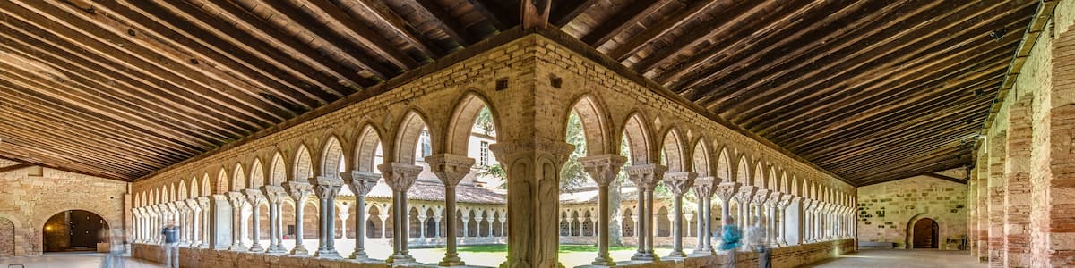 An interior courtyard with a series of arches and a wooden ceiling.
