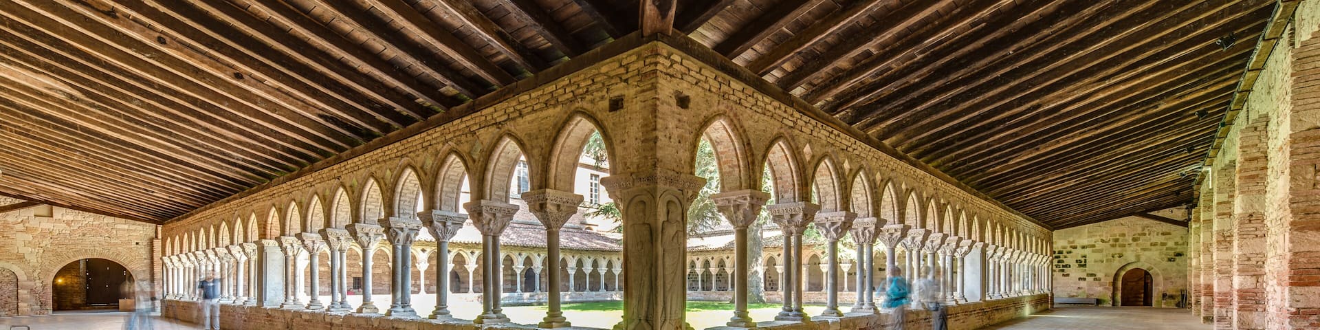 An interior courtyard with a series of arches and a wooden ceiling.