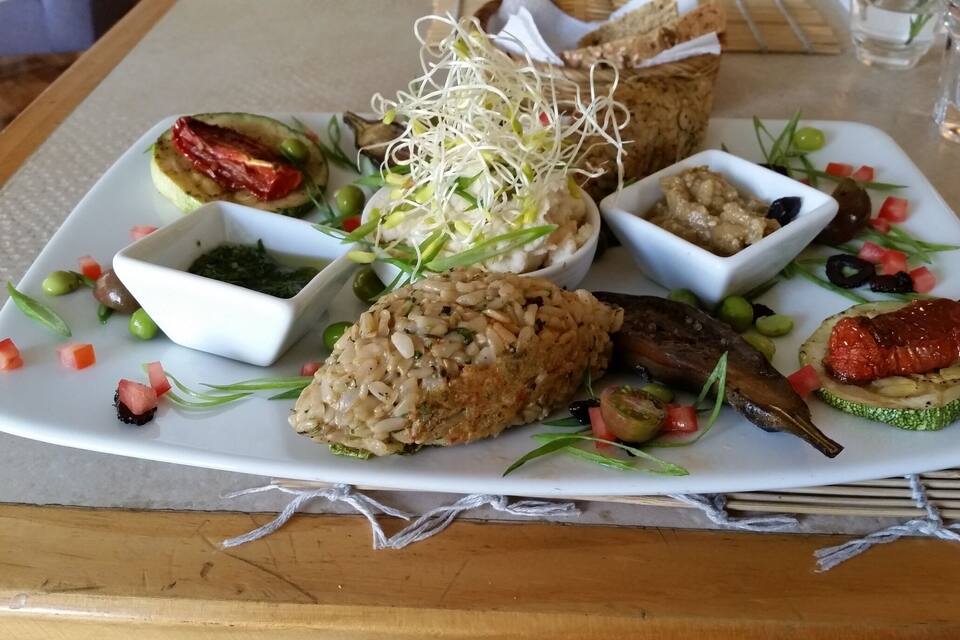 A plate of food with rice, vegetables, and a fish.