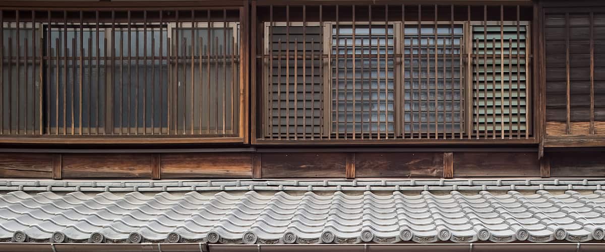 A traditional Japanese building with wooden sliding doors and tiled roof.