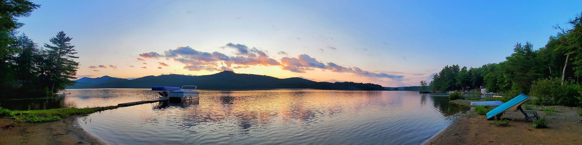 Aerial view of lake surrounded by dense trees during sunset
