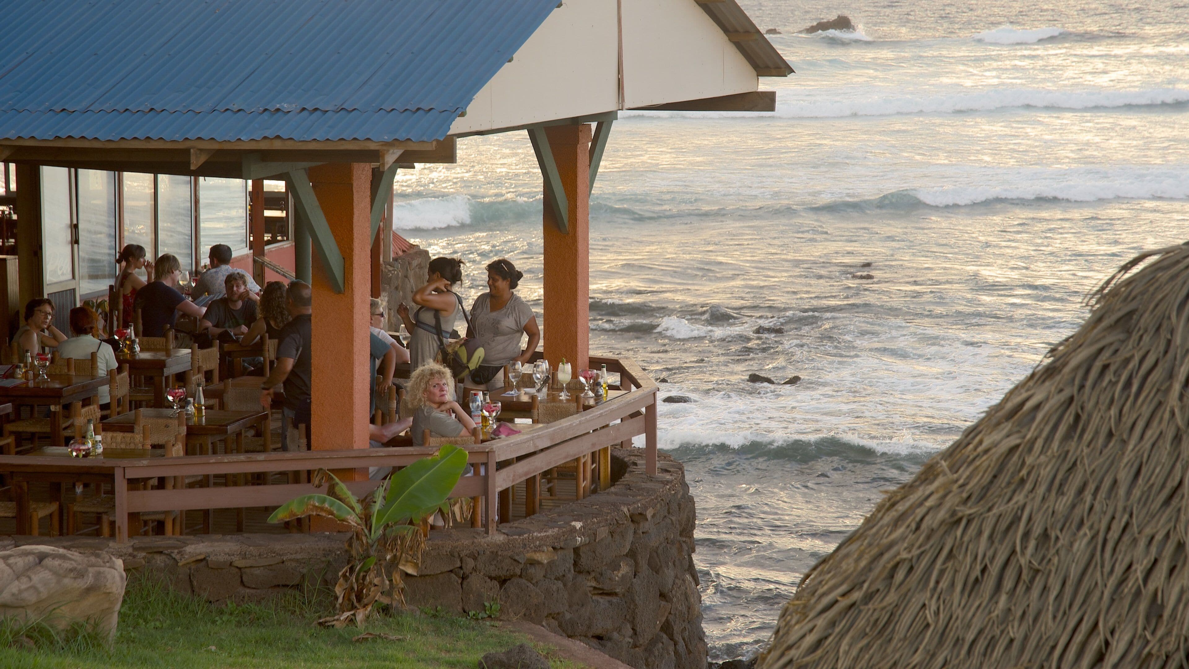 Hanga Roa ofreciendo vistas generales de la costa y salir a cenar y también un pequeño grupo de personas