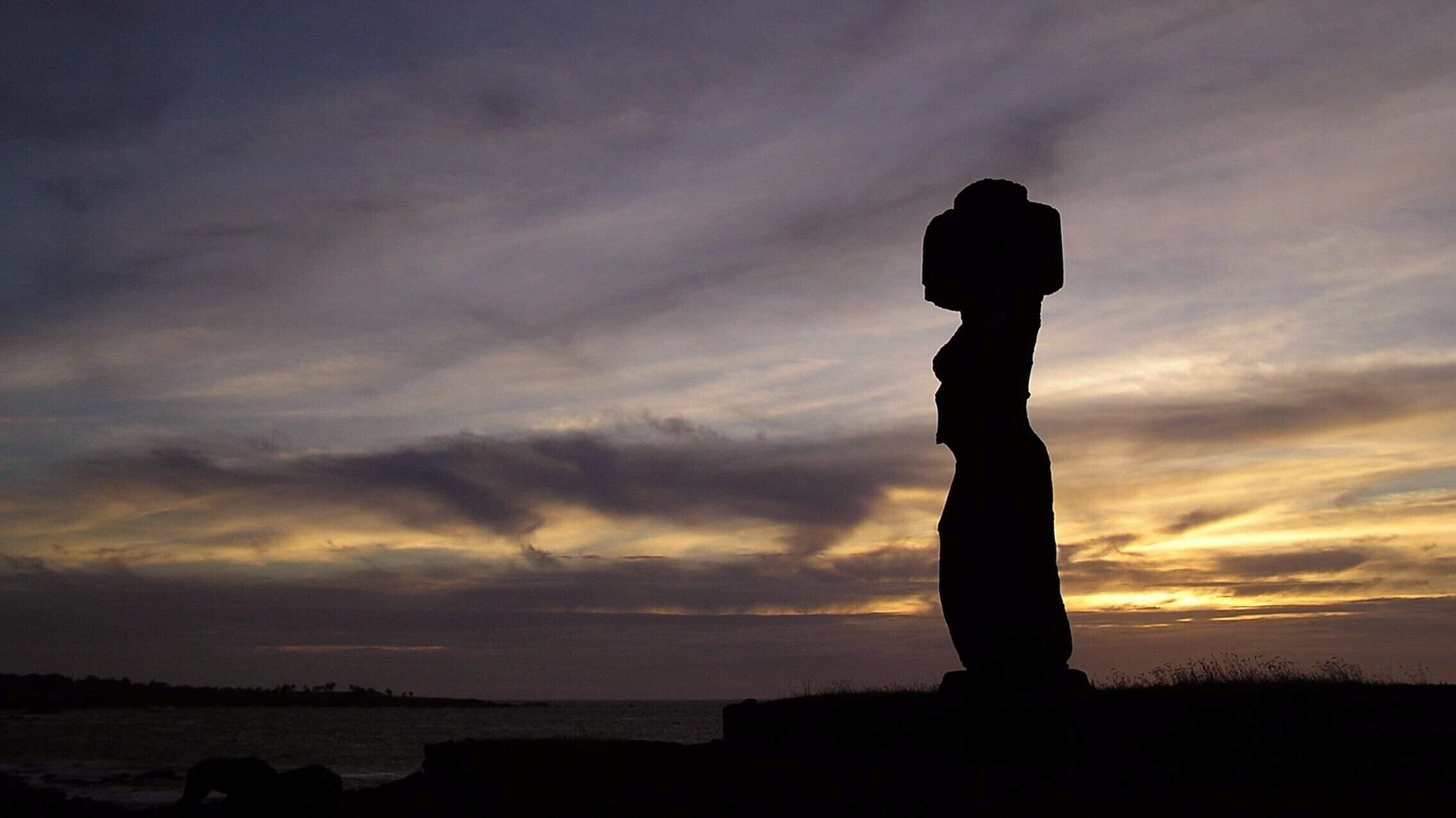 Silhueta de uma estátua contra o céu ao pôr do sol.