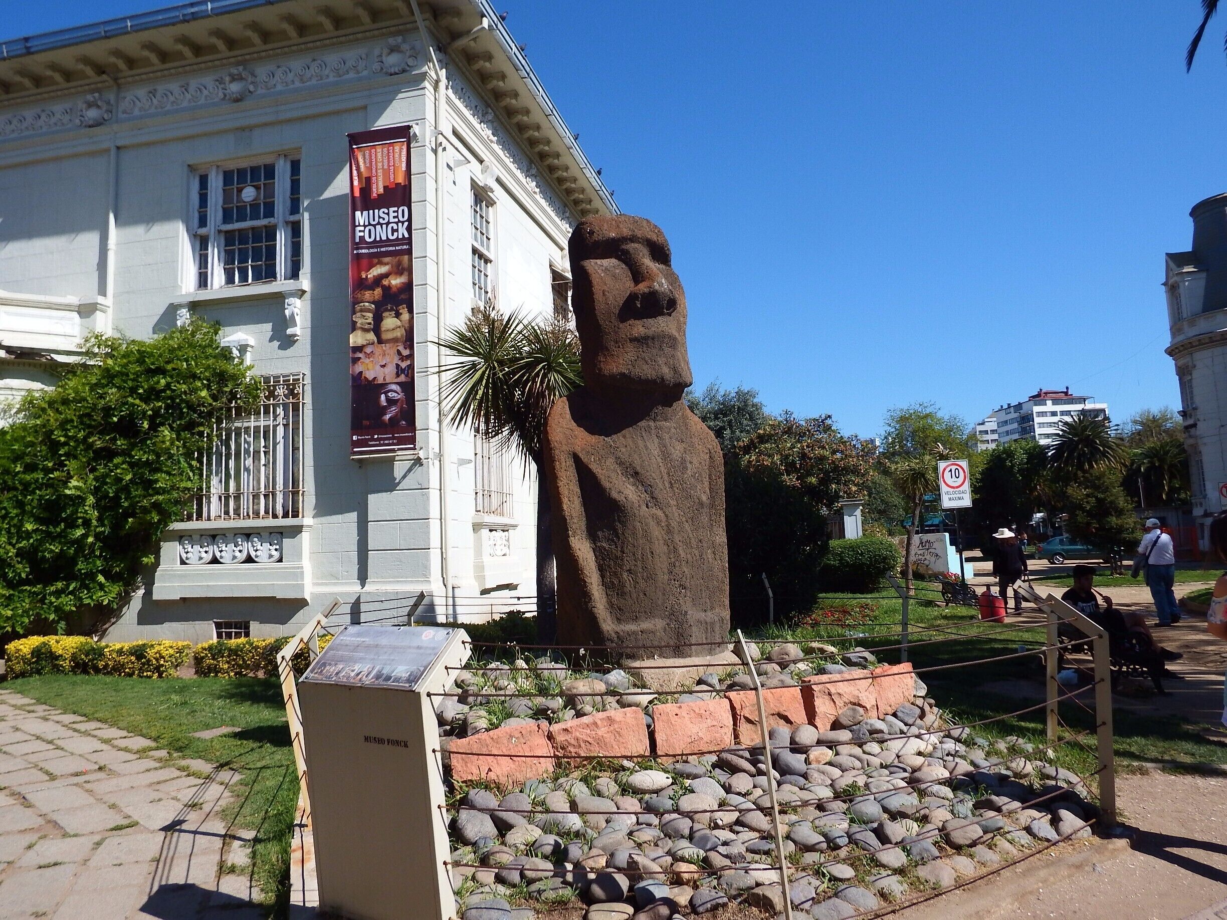 A large stone statue in front of a museum with a sign reading "Museo Fonck".