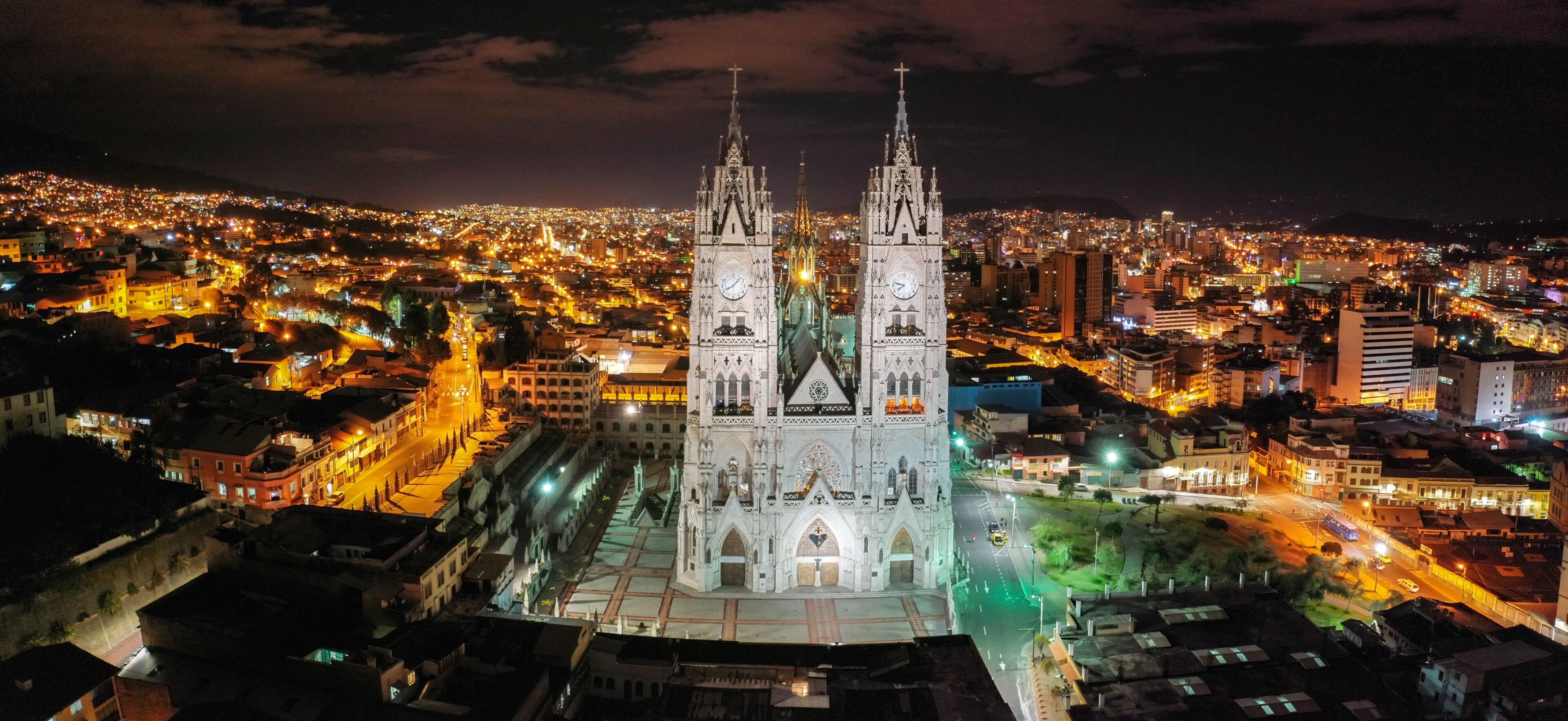 A cathedral with twin spires, a cityscape at night, and illuminated streets.