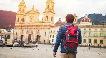 Young man traveling in Bogota, Colombia. Plaza de Bolívar, La Candelaria neighborhood. Taking some photos with the Catedral Primada.