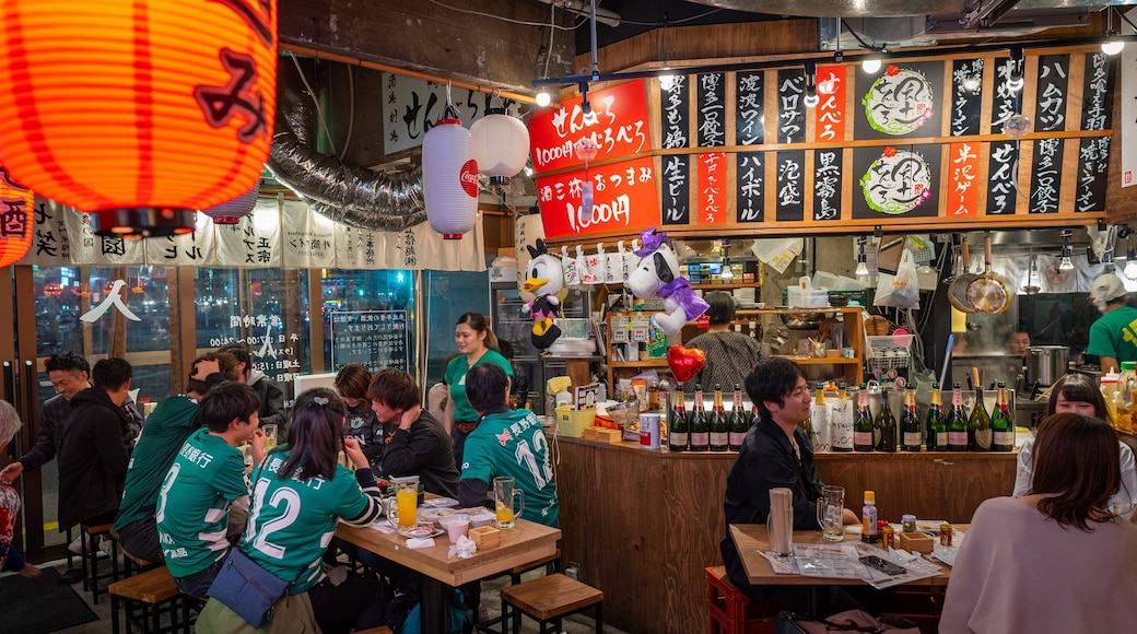 Matsumoto featuring a bar and interior views as well as a large group of people