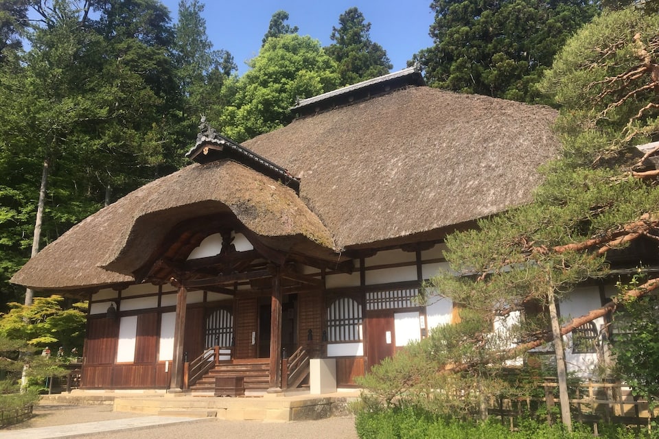 A traditional Japanese building with a thatched roof and wooden structure.