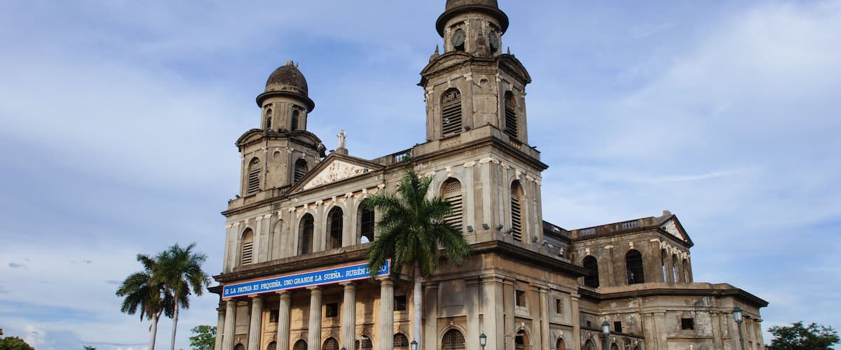 Una iglesia histórica con dos cúpulas y un alto campanario.
