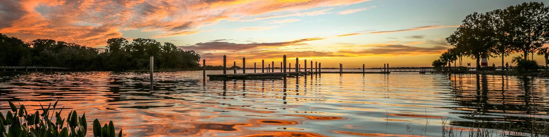 Fiery red and orange clouds and reflections on Lake Dora in Florida