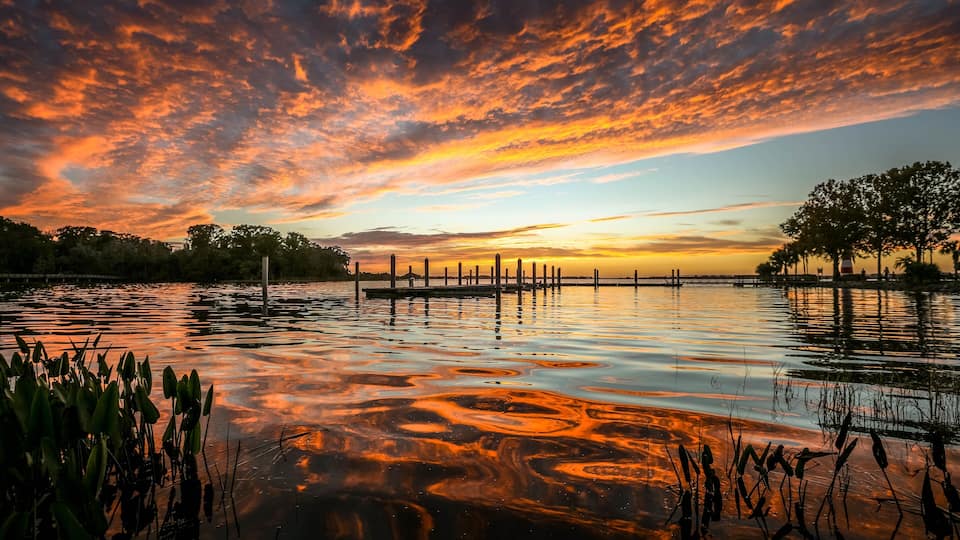 Fiery red and orange clouds and reflections on Lake Dora in Florida