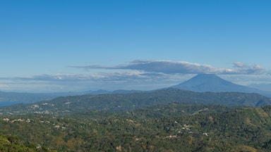 Panoramic view of a cloud capped San Miguel volcano surrounded by lush green hills and mountains. Puerto Del Diablo lookout, El Salvador.