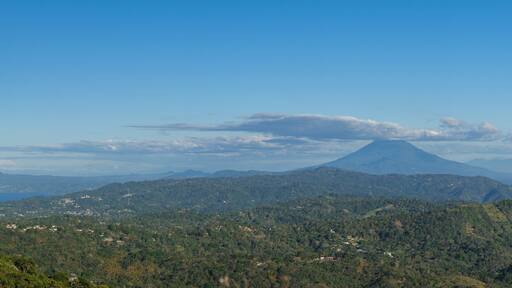 Panoramic view of a cloud capped San Miguel volcano surrounded by lush green hills and mountains. Puerto Del Diablo lookout, El Salvador.