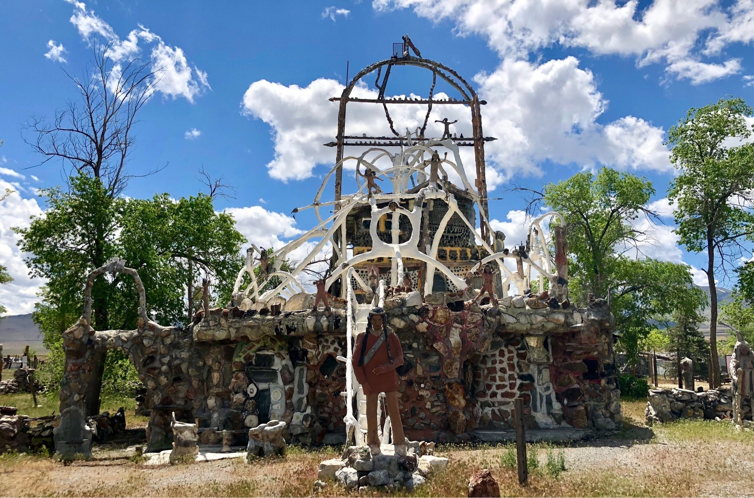 Located about 35 miles west of Winnemucca and visible from I80, the Thunder Mountain Monument was built by Frank Van Zant aka 'Chief Rolling Mountain Thunder' (1921-1989). He moved here in 1968 with his wife and three small children. He started building his unique environment using only discarded items he found within a 50 mile radius of the property. In fact, the only thing he purchased was cement. In 1983 he was named Nevada’s Artist of the Year.  Sadly, he committed suicide in 1989. His oldest son now owns the property. The grounds are open to the public. 

More info Is available here:
http://www.thundermountainmonument.com/index.htm