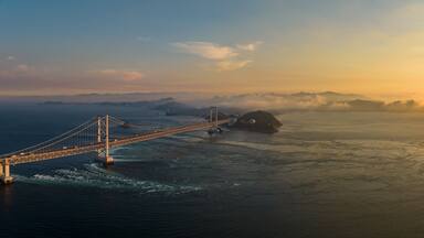Panoramic aerial view of Naruto Bridge and whirlpools at sunset