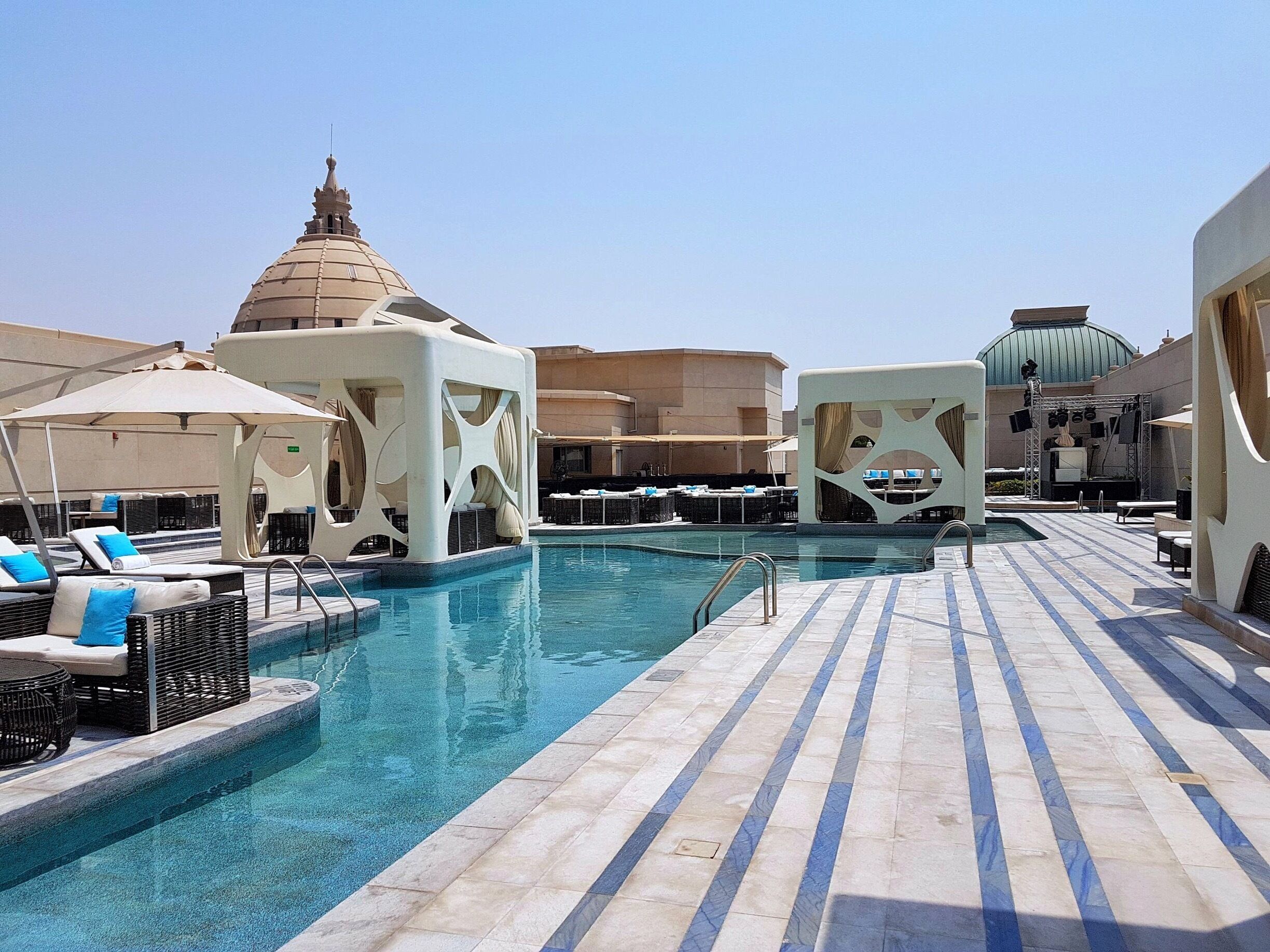 Uma área de piscina no terraço com espreguiçadeiras e guarda-sóis.