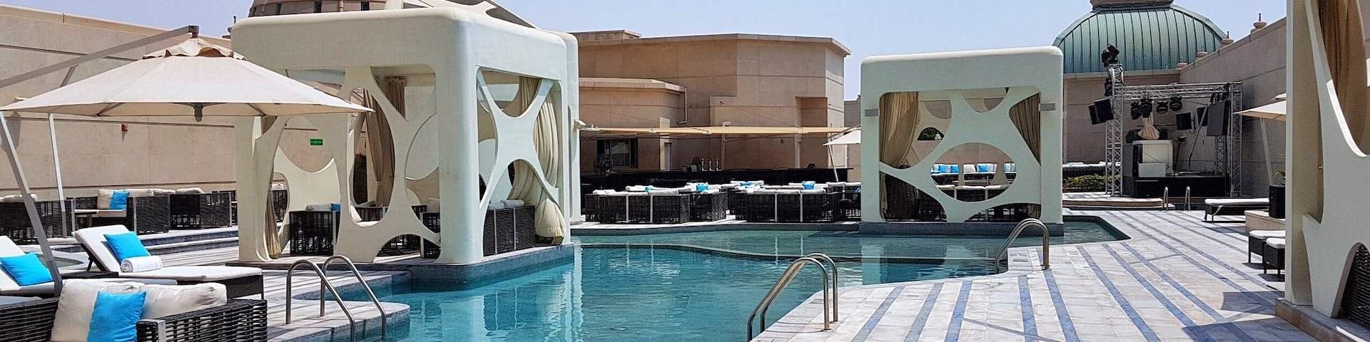 Uma área de piscina no terraço com espreguiçadeiras e guarda-sóis.