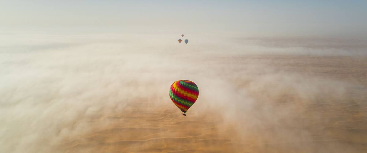 A hot air balloon over a vast desert landscape.