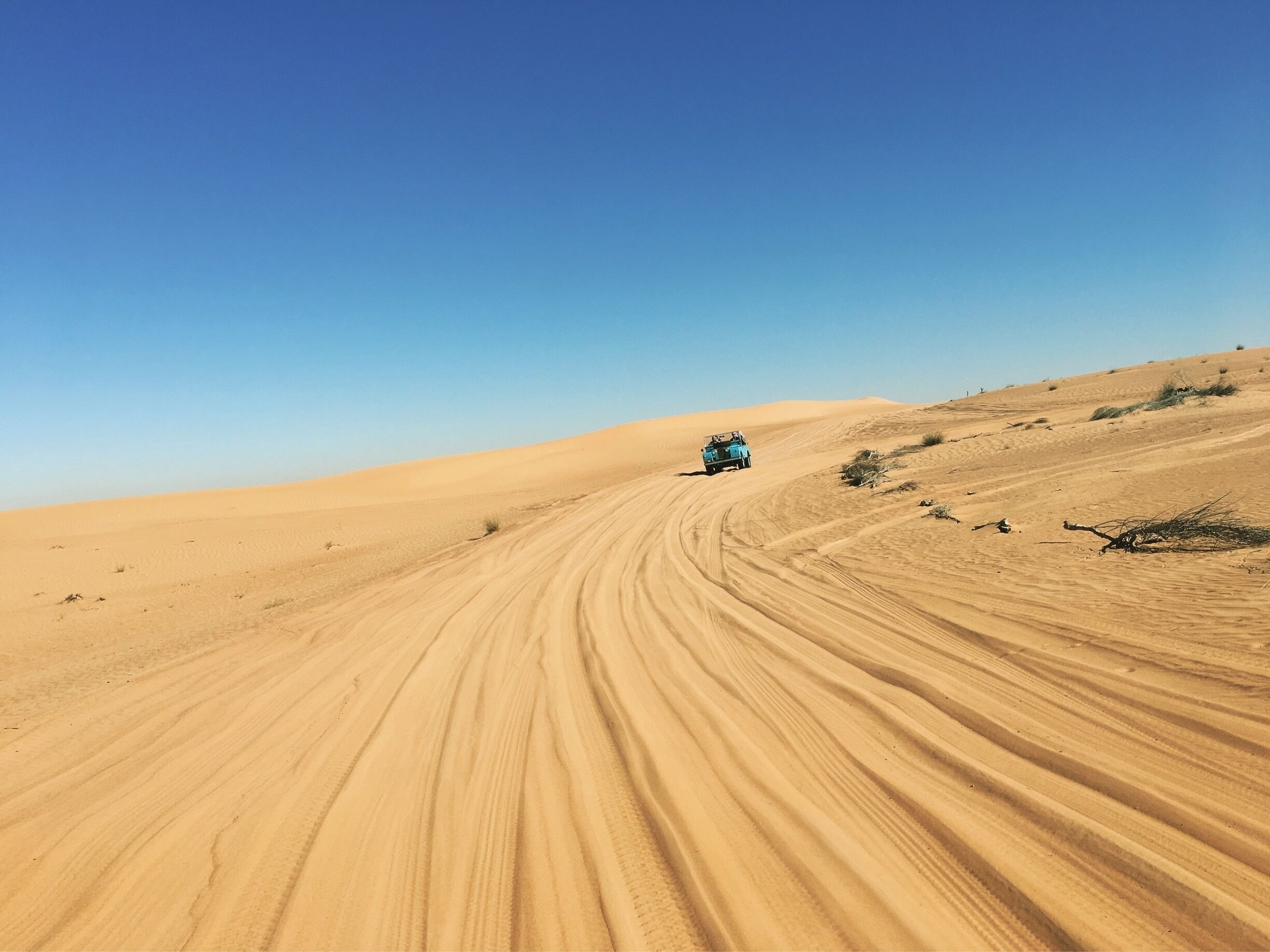 In a vintage land rover out in the desert
