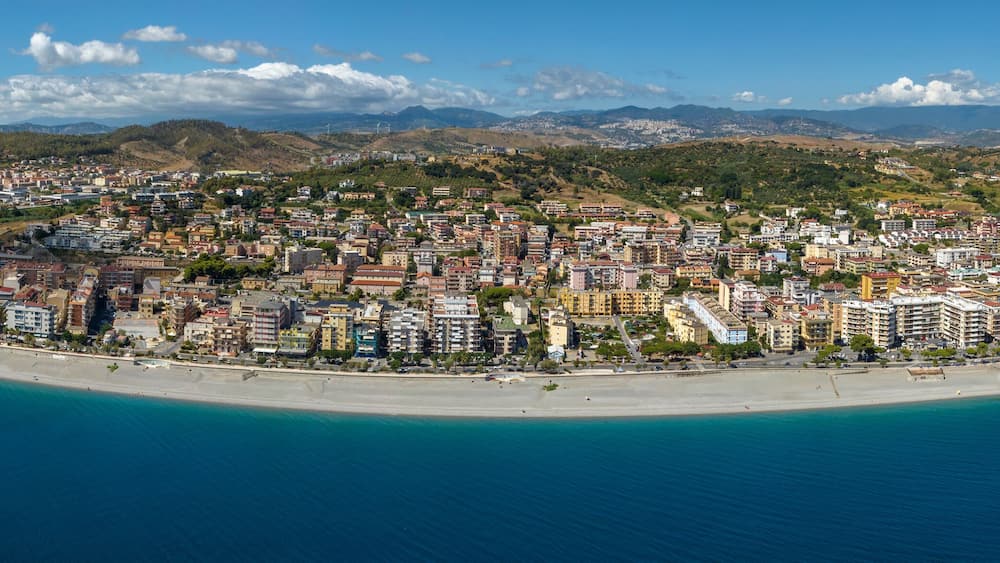 Panoramic aerial view of Catanzaro Lido, Calabria, Italy. It is the seaside district of the Calabrian capital. There are houses, buildings, and a waterfront promenade overlooking the Ionian Sea.