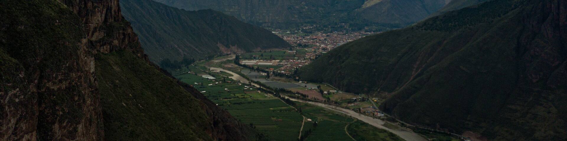 Aerial view on town located in Sacred Valley of Incas in Cusco, Peru. Mountains surrounding the river basin and towns with clouds