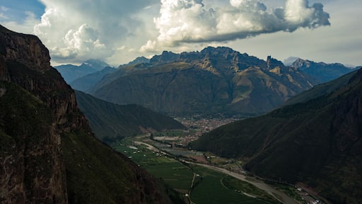 Aerial view on town located in Sacred Valley of Incas in Cusco, Peru. Mountains surrounding the river basin and towns with clouds