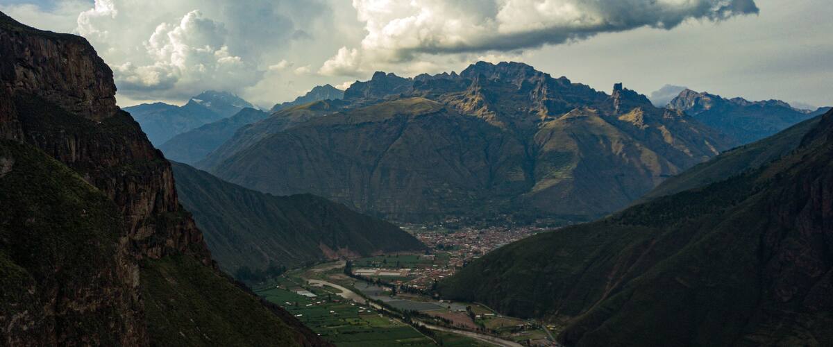 A valley with a river, surrounded by mountains and a town.