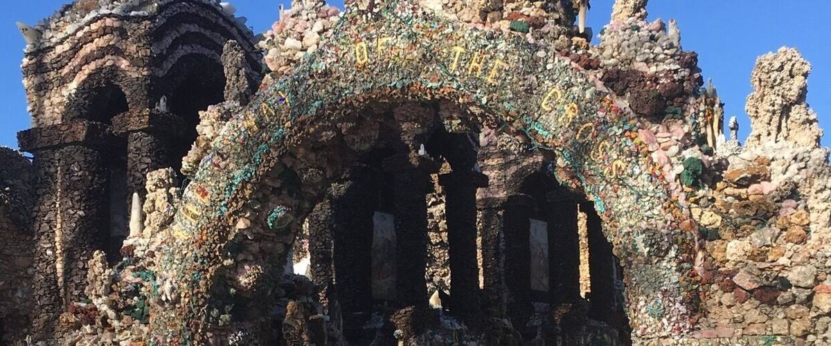 A historic building with intricate mosaic decorations and a large archway.