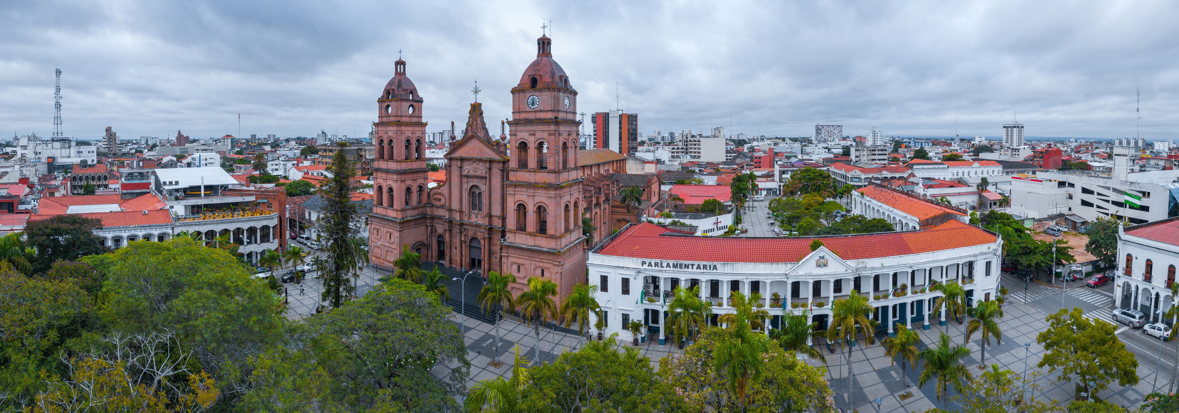 A historic building with a clock tower and a white building with balconies.