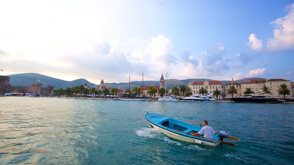A coastal town with a historic castle, a church, and a marina with boats.