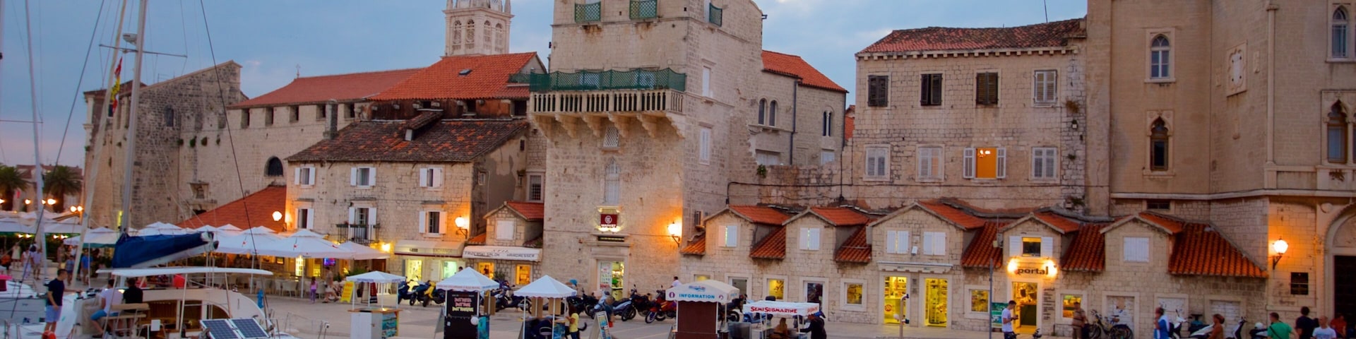 A harbor with boats, a red submarine, and historic buildings.