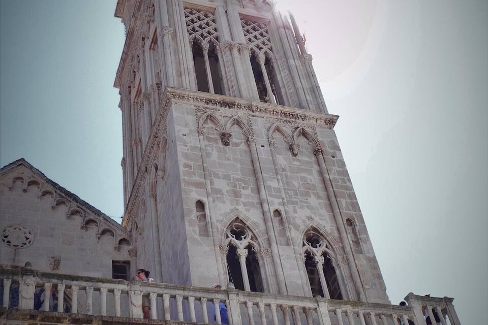 A tall, ornate cathedral with intricate stone carvings and a prominent bell tower.