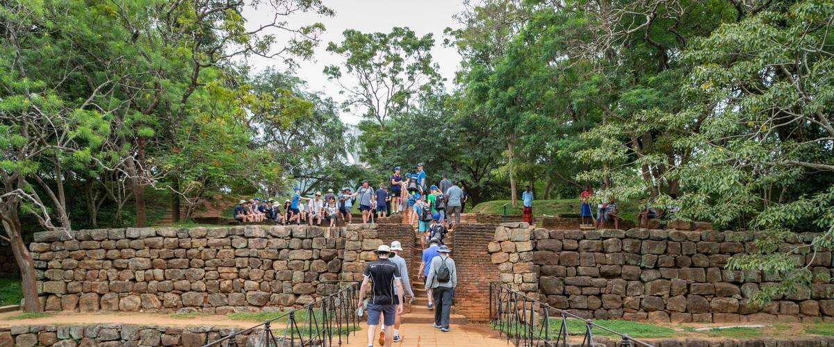 Sigiriya featuring a bridge and a garden as well as a small group of people