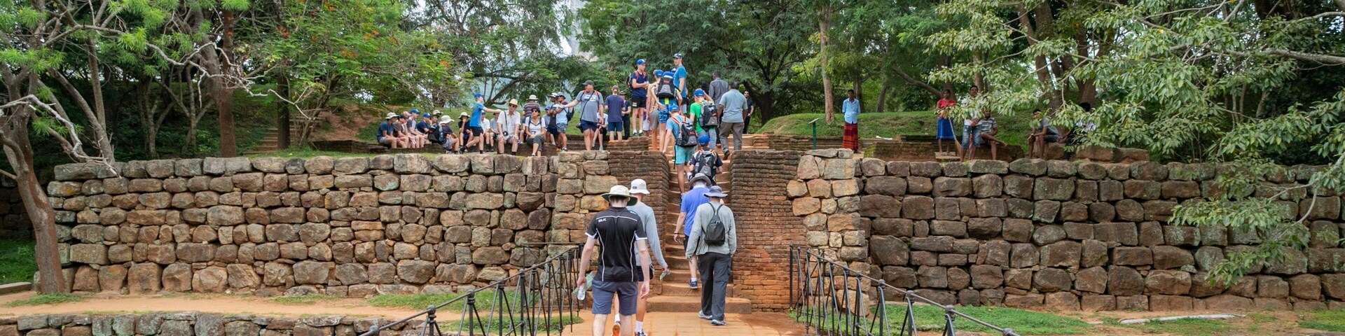 Sigiriya featuring a bridge and a garden as well as a small group of people