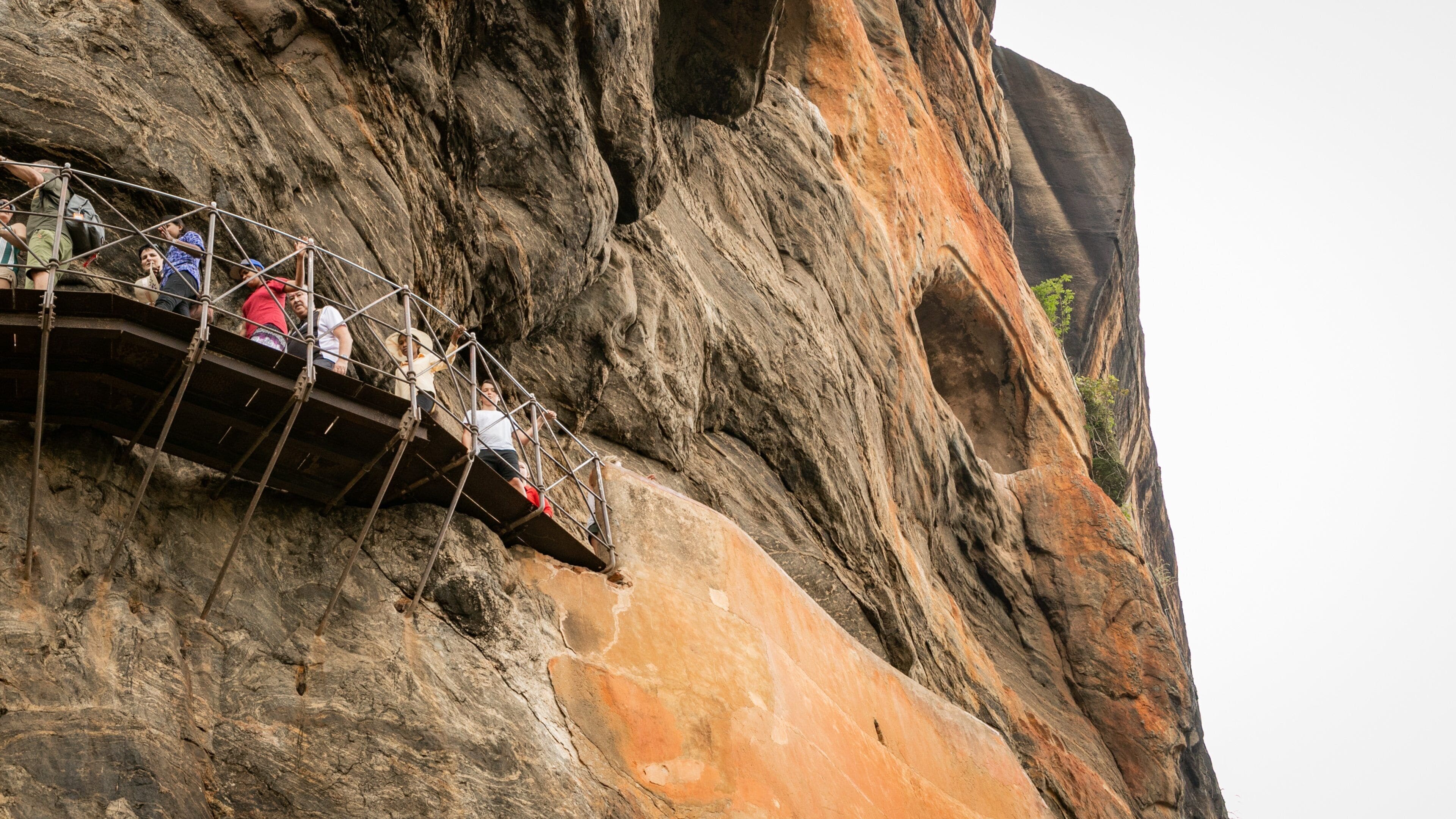 Sigiriya featuring a gorge or canyon and views as well as a small group of people