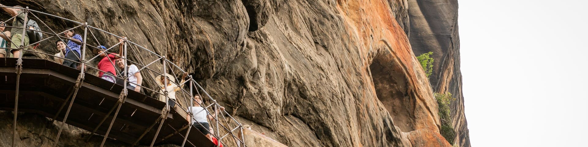 Sigiriya featuring a gorge or canyon and views as well as a small group of people