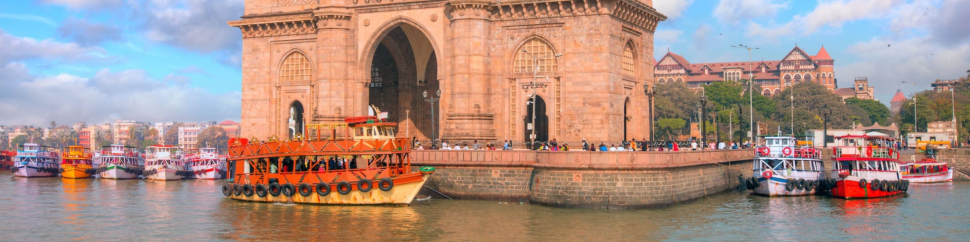 Hot air balloon flying over The Gateway of India and boats as seen from the Harbour - Mumbai, India