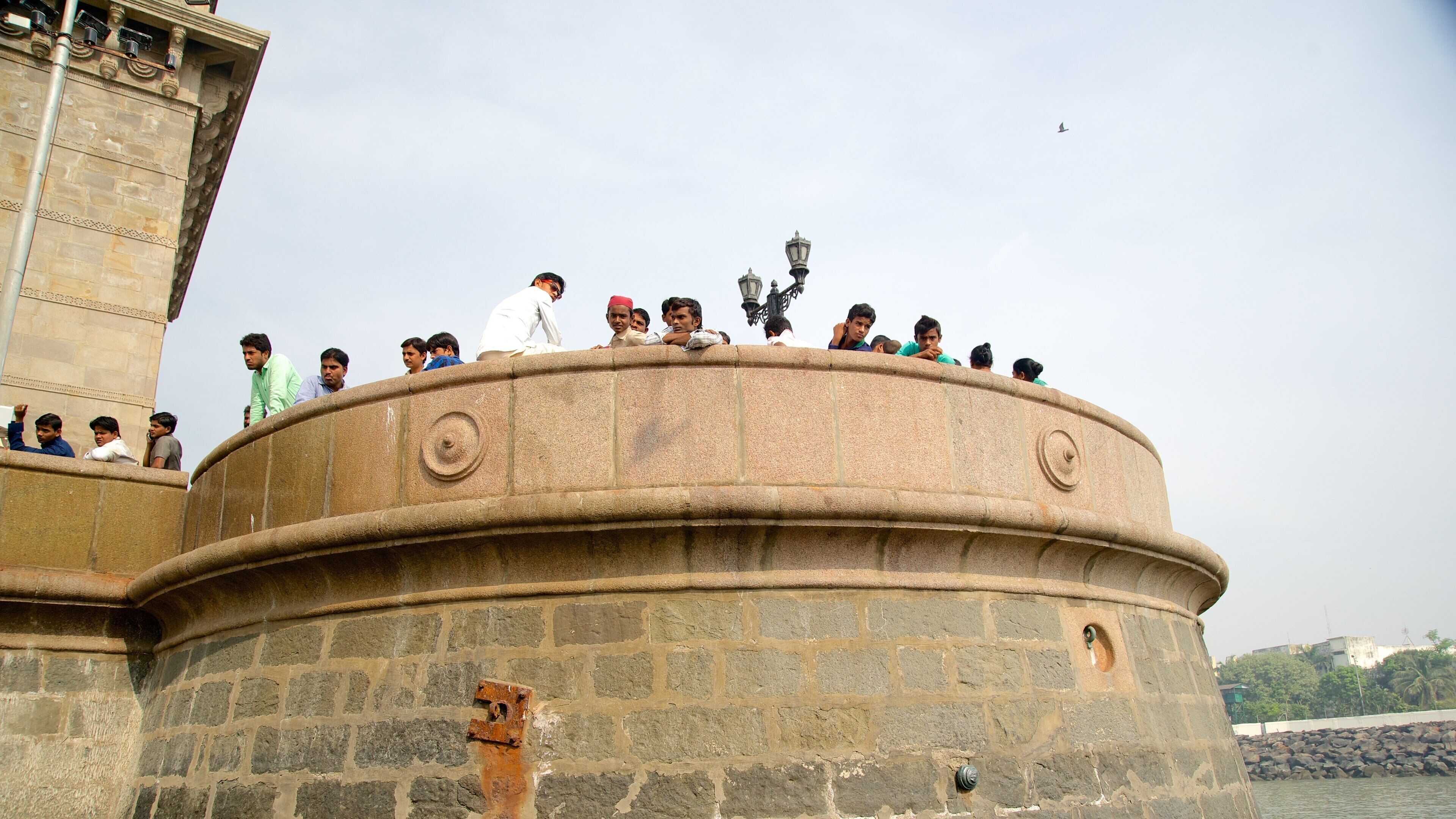 Gateway of India featuring heritage architecture and heritage elements as well as a small group of people
