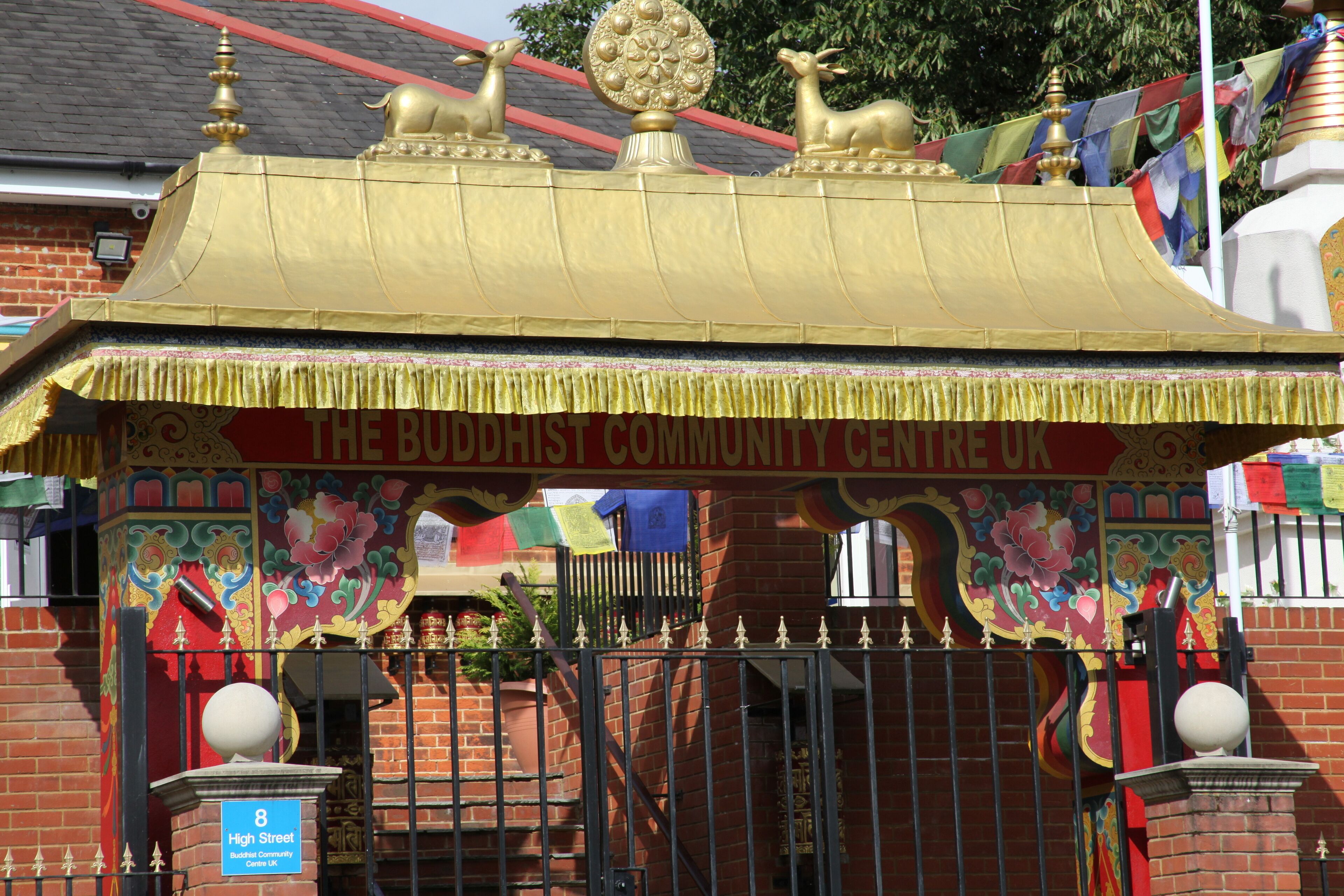 A Buddhist community center with a golden roof and colorful decorations.