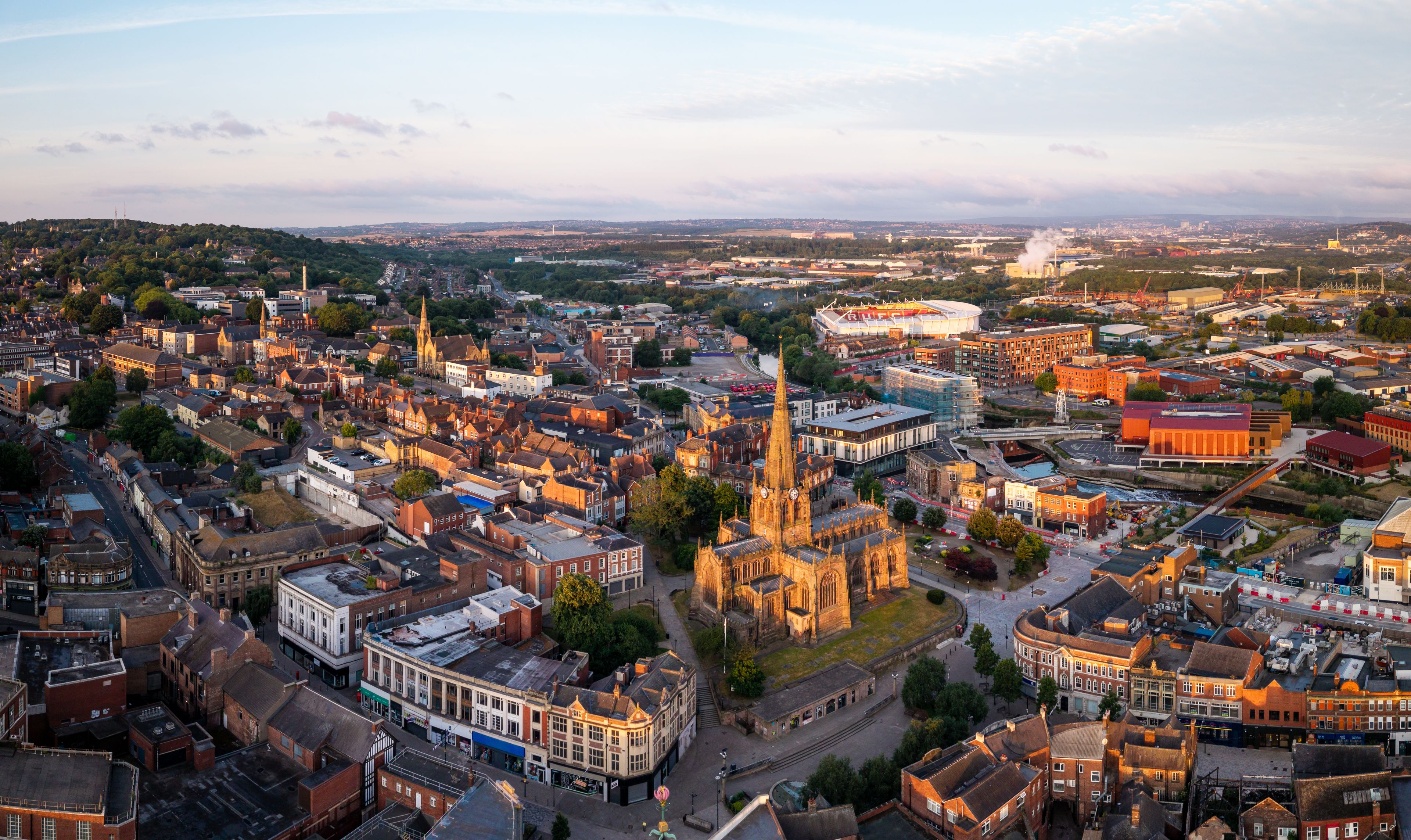 A cityscape with a prominent cathedral, a stadium, and a mix of historical and modern buildings.