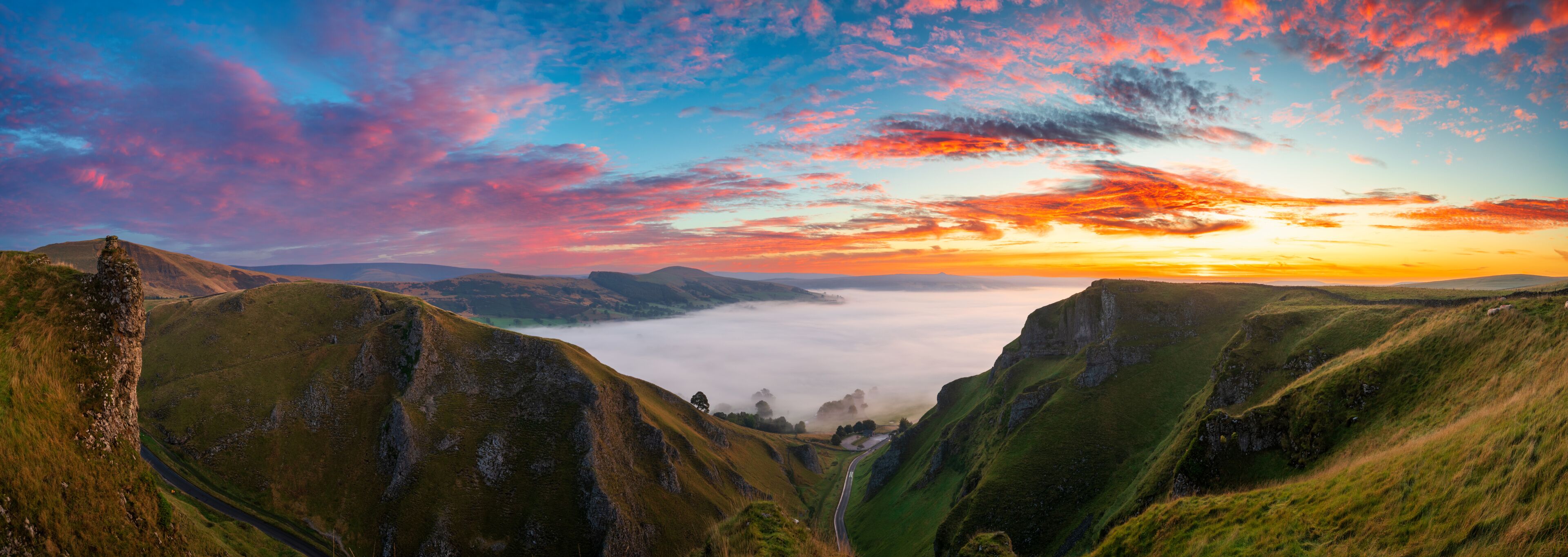 Winnats Pass sunrise panorama with cloud investion in the valley over Castleton. Peak District. England