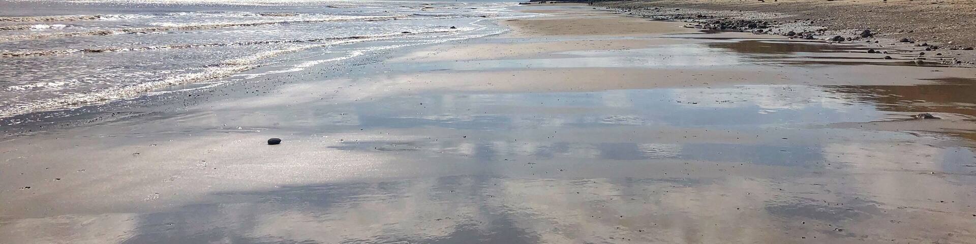 A beach with a clear sky and gentle waves.