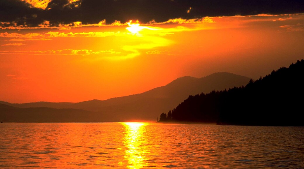 Northern Idaho featuring a lake or waterhole and a sunset