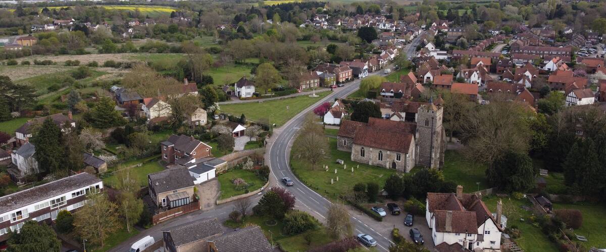 A rural village with a winding road, houses, and a church.