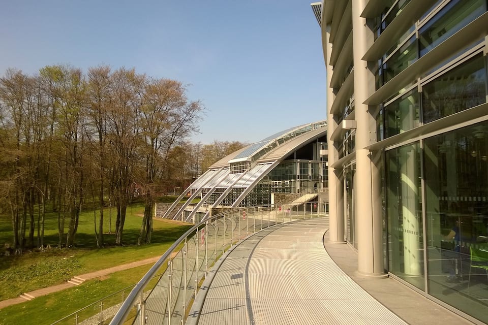 A modern building with a glass facade and a curved roof.