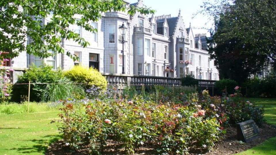 Rubislaw Terrace Gardens Manicured lawns with memorial rose bed facing the main thoroughfare of Albyn Place. The granite terrace of former houses now mainly holds offices.
